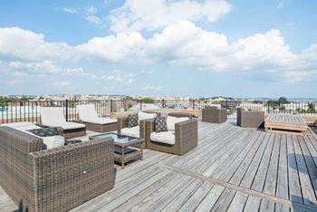 A rooftop deck with lounge chairs  at 1841 Columbia Road Apartments